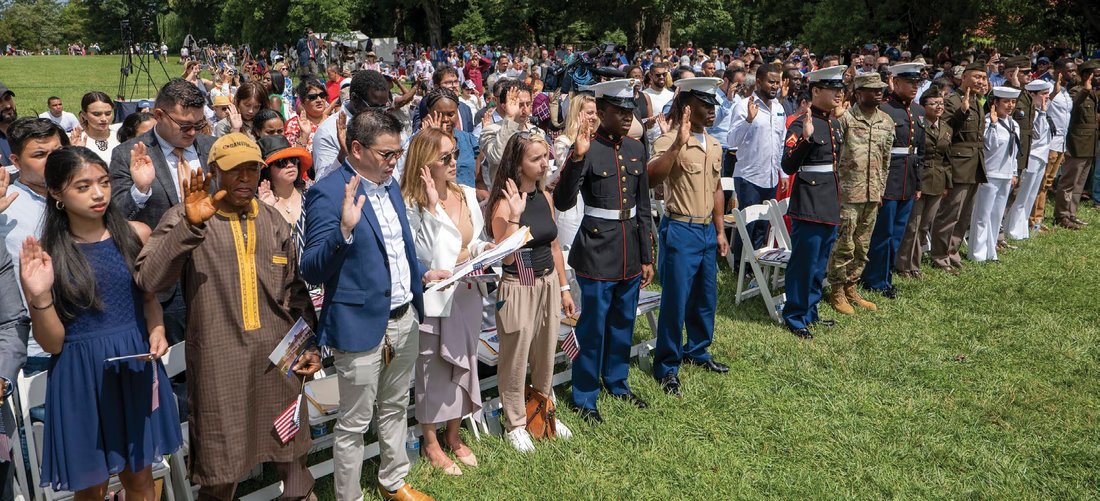 Applicants for naturalization take the Oath of Allegiance at a naturalization ceremony.